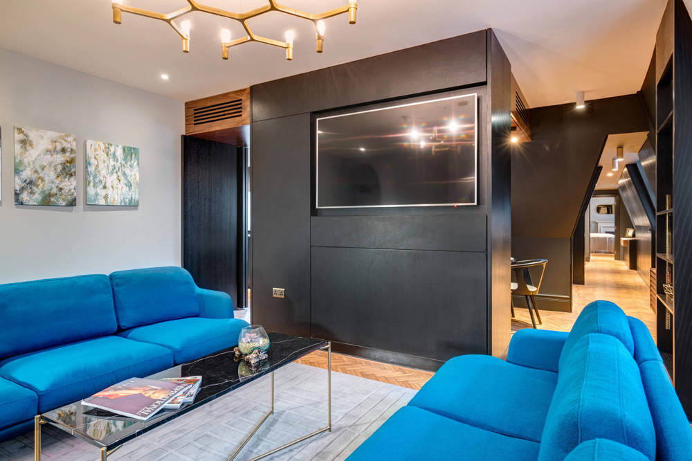 Living area with sofas and TV in Temple Suite at Apex Temple Court Hotel