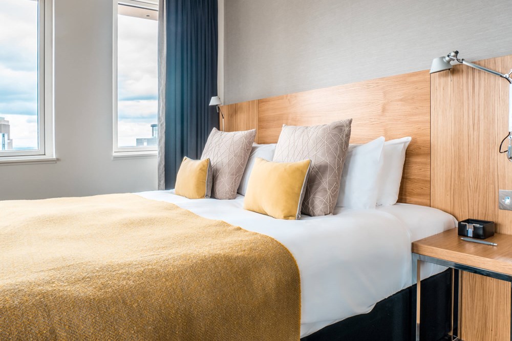 Deluxe Room with king-size bed and sofa at Apex Waterloo Place Hotel
