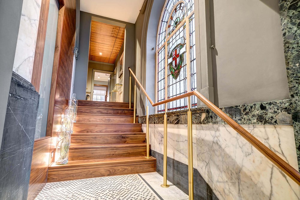 Grand Suite hallway with stairs and stained glass window at Apex Temple Court Hotel