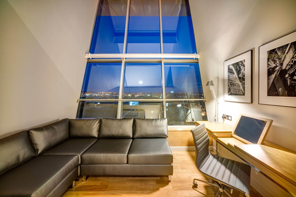 Duplex Suite lounge area with sofa and TV and city view