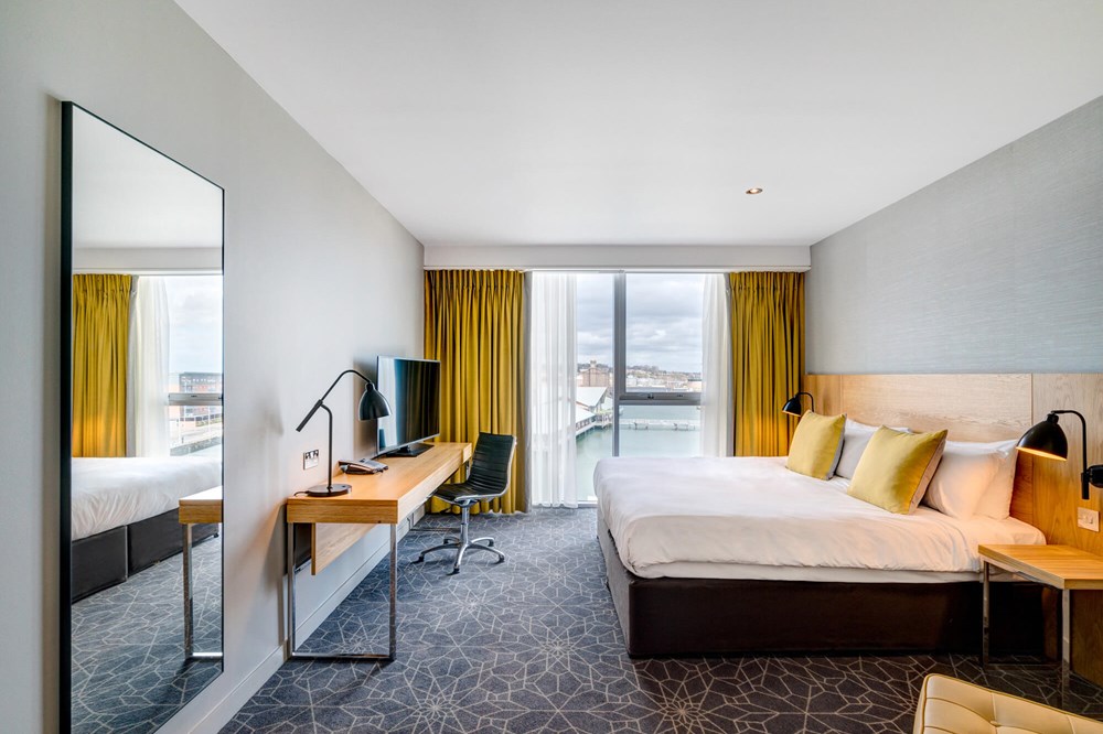 King-size bed with TV on desk and Quay Views