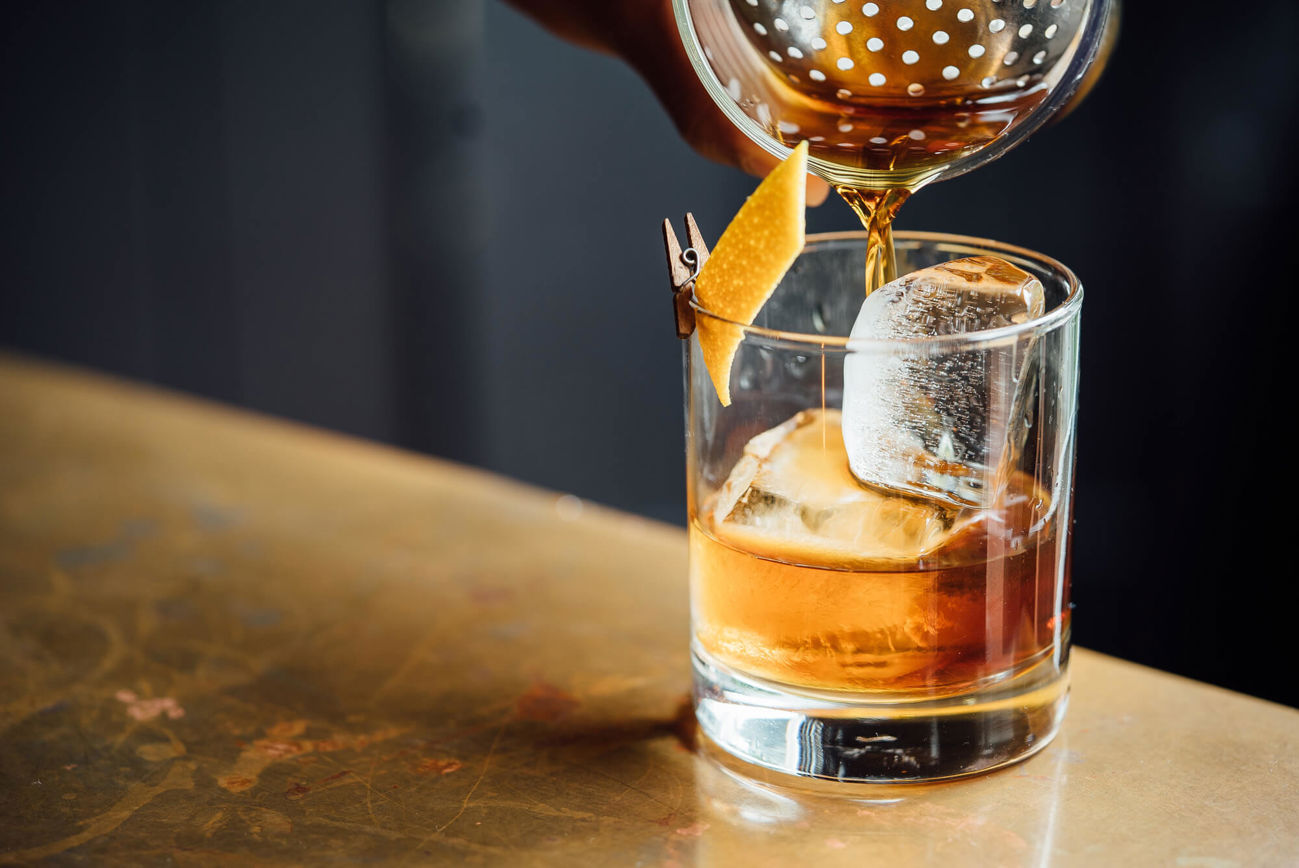 Whisky being poured into glass with ice