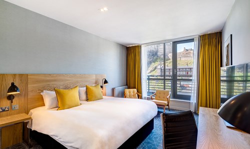 Double bed with views onto Edinburgh Castle in Apex Grassmarket's Deluxe Castle View Room
