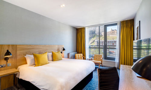 Deluxe Room With Castle View at Apex Grassmarket Hotel Double bed with views onto Edinburgh Castle in Apex Grassmarket's Deluxe Castle View Room