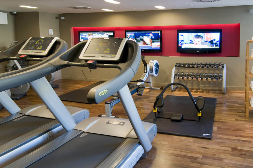 24-hour gym at Apex Waterloo Place Hotel gym with treadmills and TV screens