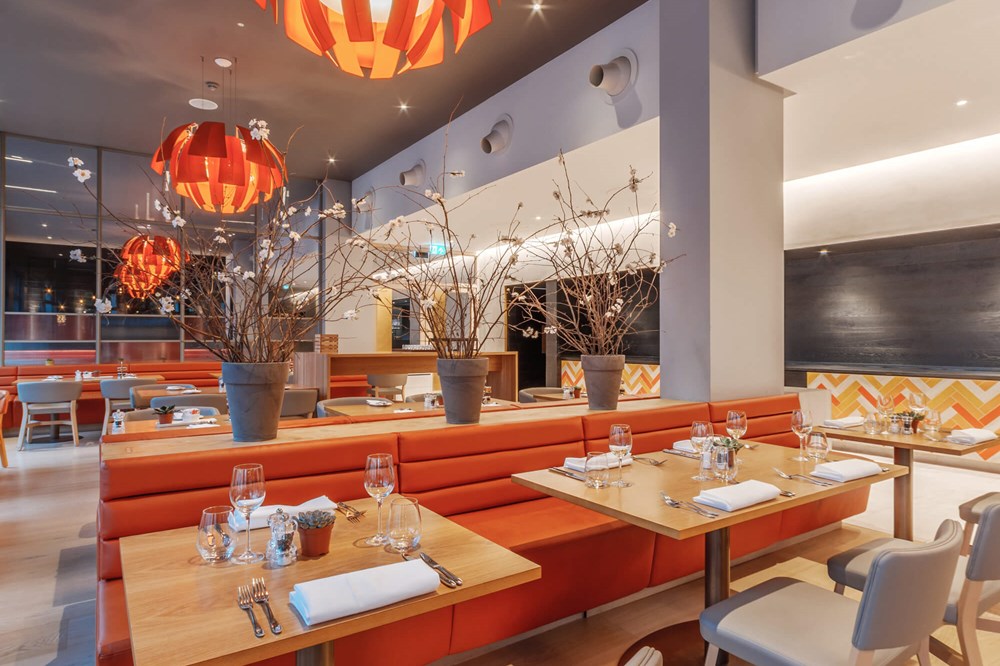 The Orange Artichoke restaurant at Apex City of Bath Hotel with orange chairs and tables