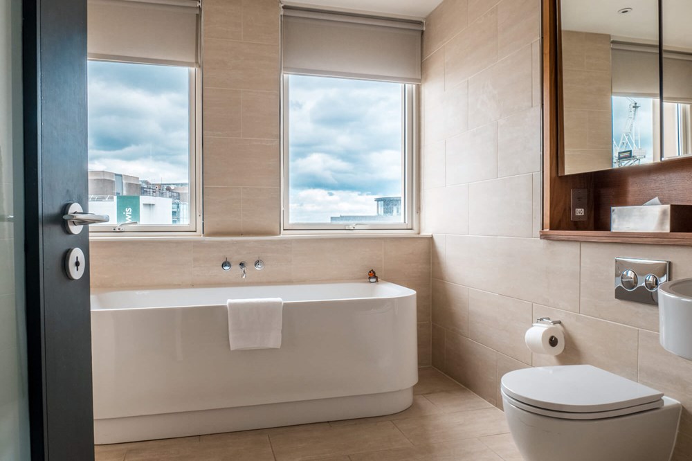 Deluxe Room bathroom with freestanding bath at Apex Waterloo Place Hotel