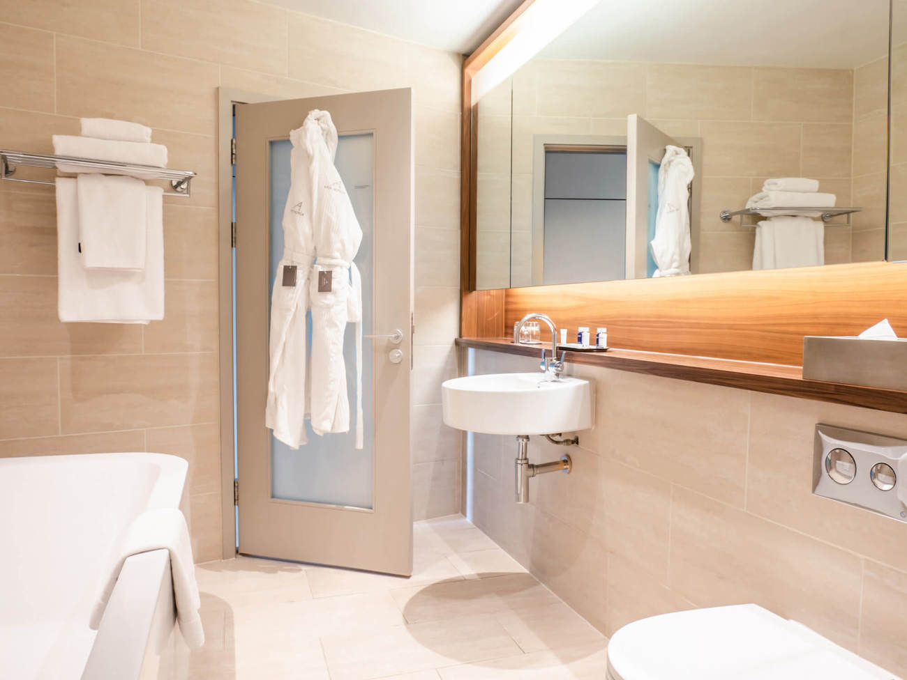 Superior Room bathroom at Apex Waterloo Place Hotel Bathroom in Superior Room at Apex Waterloo Place Hotel with bath, large mirror and robes hanging on door