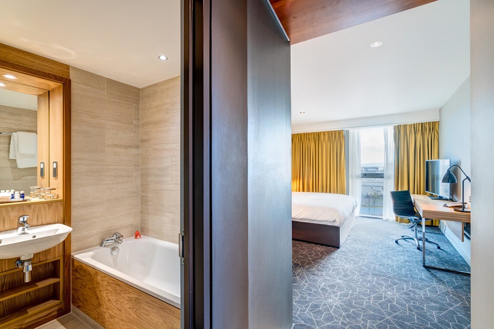Bathroom with tub and bedroom with king-size bed