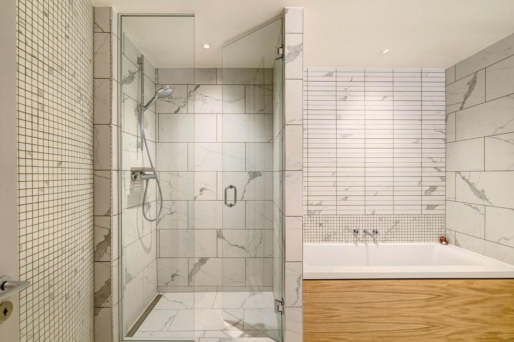 Duplex Suite bathroom with marble tiles, walk-in shower and bath at Apex Waterloo Place Hotel