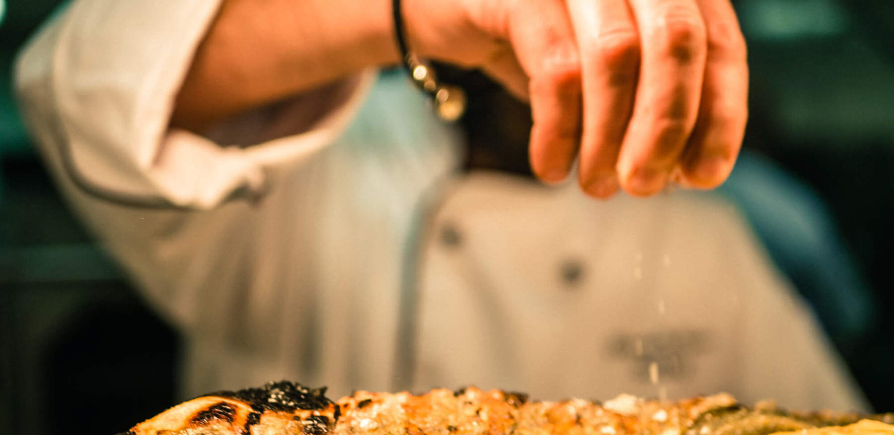 Off The Wall Bar & Grill Chef preparing seabass at Off The Wall Bar & Grill