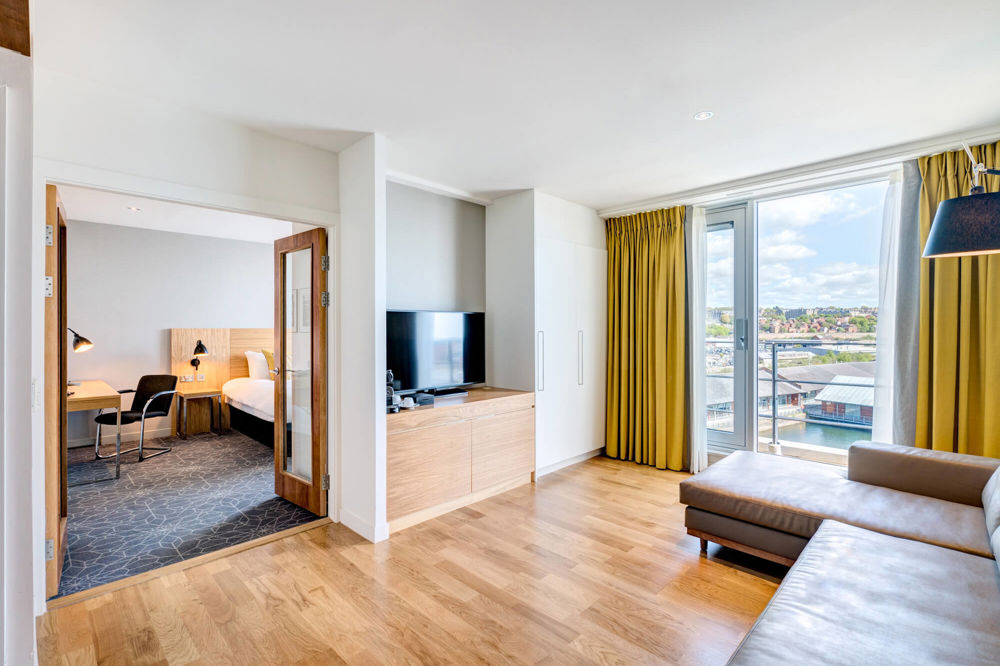Master Suite at Apex City Quay Hotel & Spa Master Suite living area with large L-shaped sofa and TV