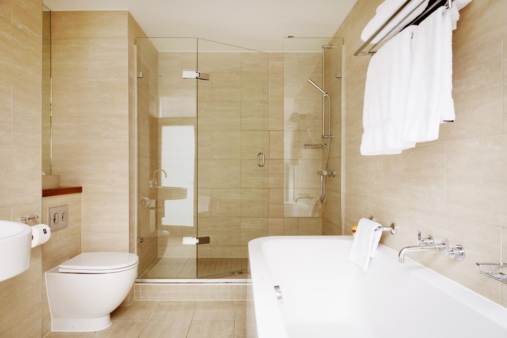Superior Room bathroom with walk-in shower and free standing bath at Apex City of London Hotel