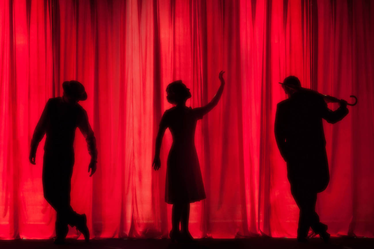 Theatre performers Theatre performer shadows in front of red curtain