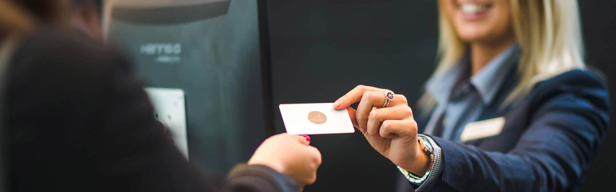 Receptionist handing over key card to guest at check in