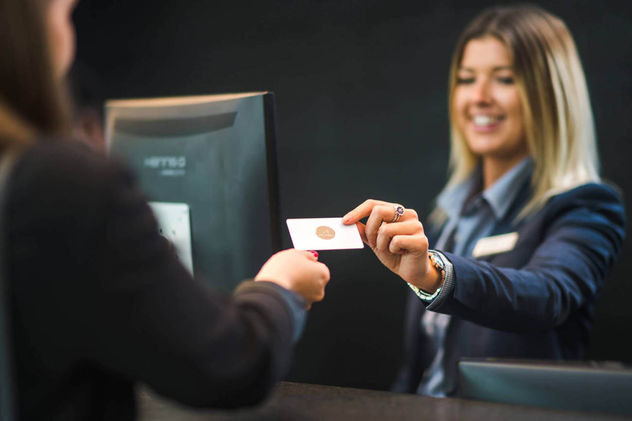 Gift vouchers at Apex Hotels Receptionist handing over hotel room key