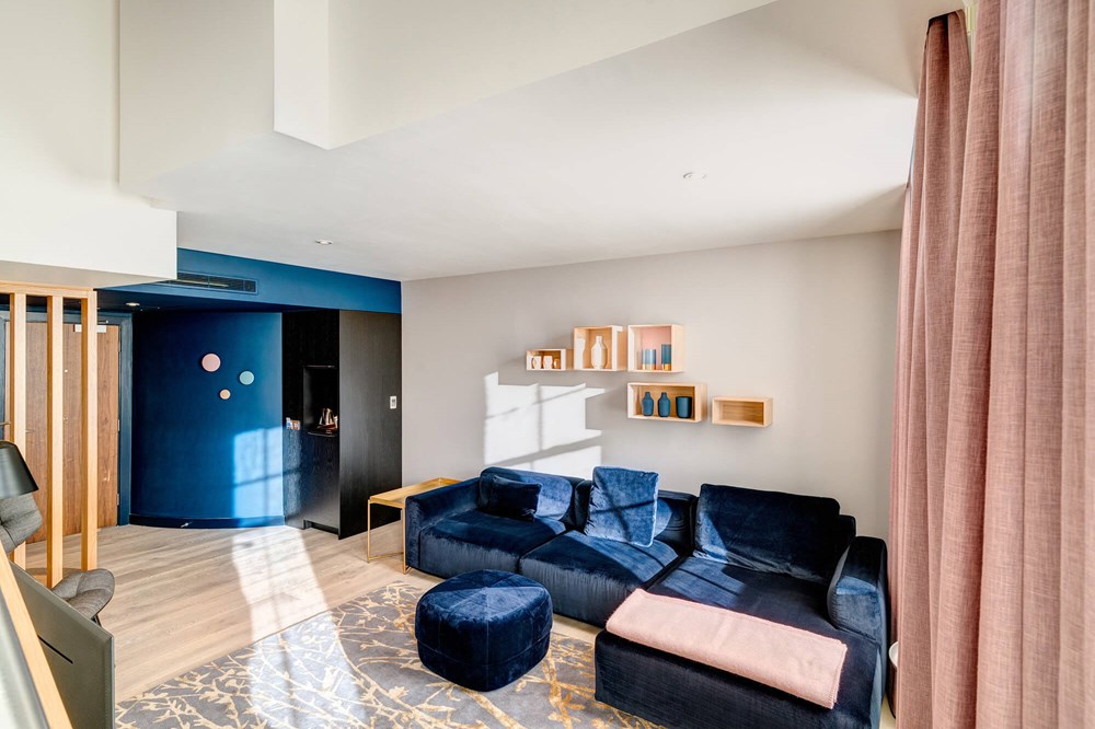 Duplex Suite living area with blue velvet corner sofa at Apex Waterloo Place Hotel