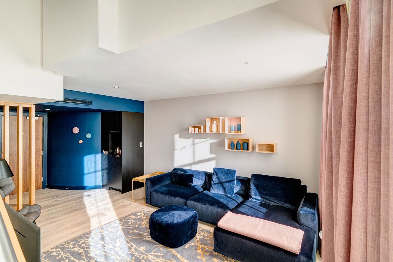 Living area with blue velvet corner sofa in Duplex Suite at Apex Waterloo Place Hotel