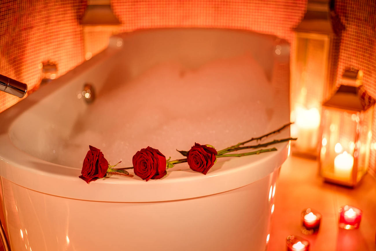 Luxury bubble bath Bubble bath with candles and red roses