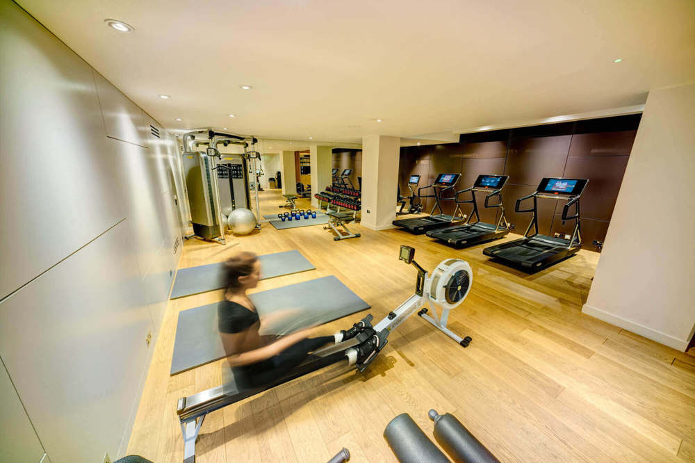 24-hour gym at Apex Temple Court Hotel Guest using rowing machine in gym